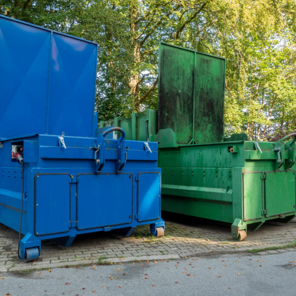 two,garbage,compactors,standing,next,to,each,other,on,the